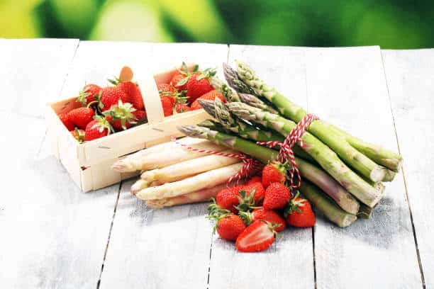 White and green fresh asparagus with a bunch of healthy strawberries